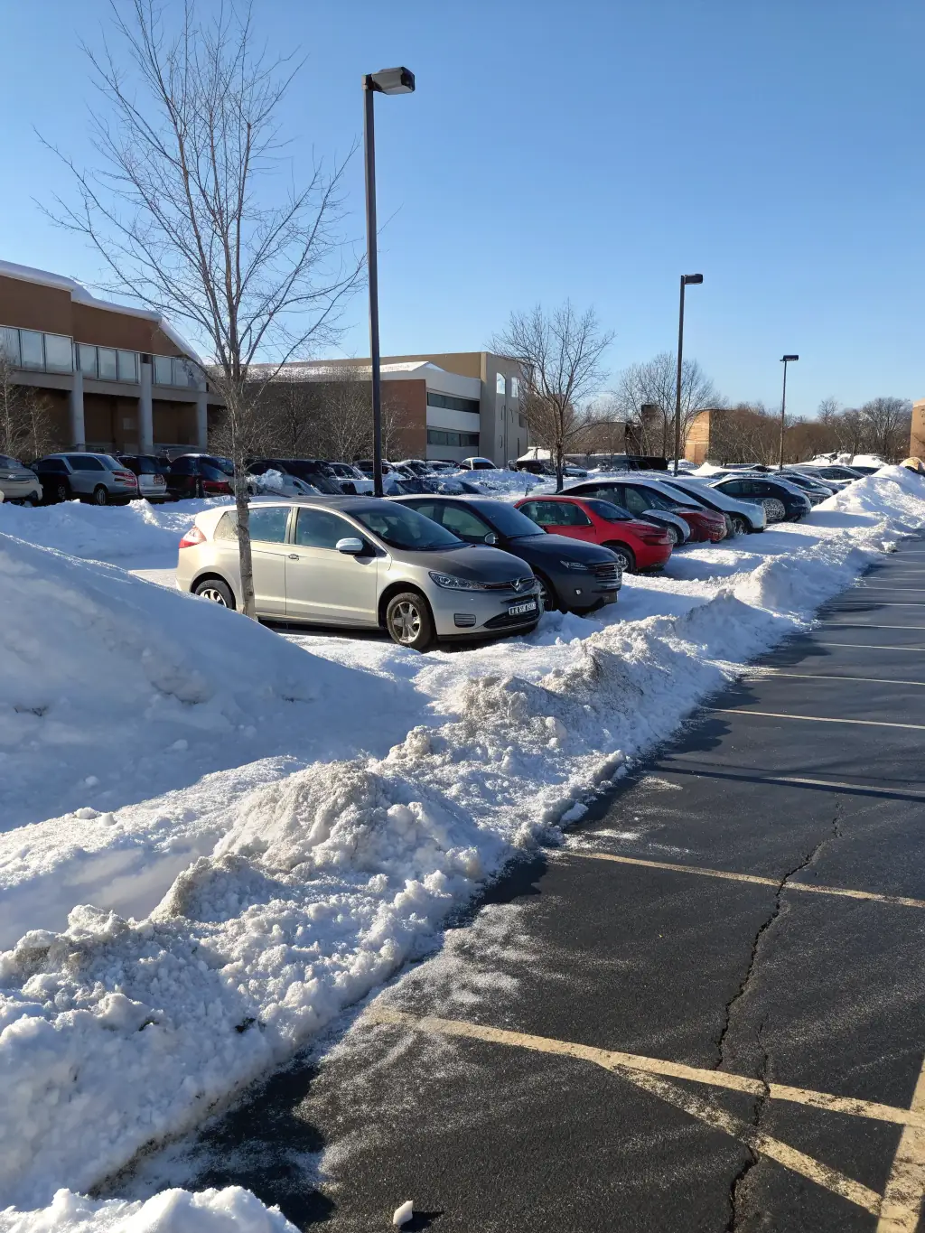 A commercial parking lot being cleared of snow by Pros On Point Services LLC, highlighting their ability to handle large-scale snow removal projects.